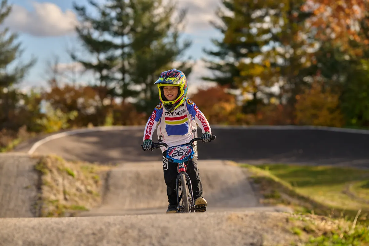 一位 XKIDS 小学员身穿全套 BMX 比赛装备在赛道上。