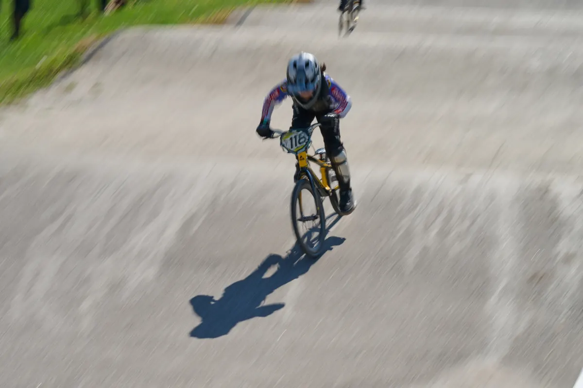 一位 XKIDS 小学员沿着 BMX 赛道向下冲刺。